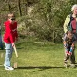 SpeelKubb brengt sport en spel samen op Second Tent Event Kinderen oefenen met het werpen van houten kubb-blokken tijdens een kubbworkshop van SpeelKubb op een grasveld.